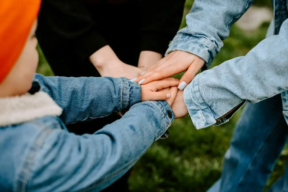 Three people with their hands in a circle